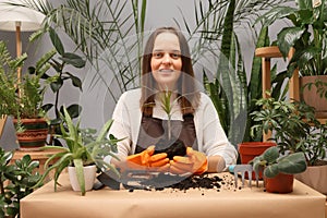 Floral business entrepreneur. Gardening and botany hobby. Florist working with plants. Smiling young woman botanist wearing apron