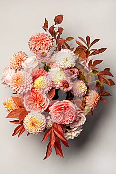 Floral composition of dahlia flowers, roses and autumn leaves.