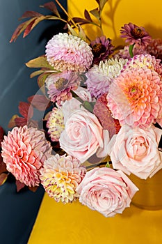 Floral composition of dahlia flowers, roses and autumn leaves.