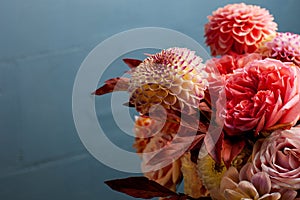 Floral composition of dahlia flowers, roses and autumn leaves.