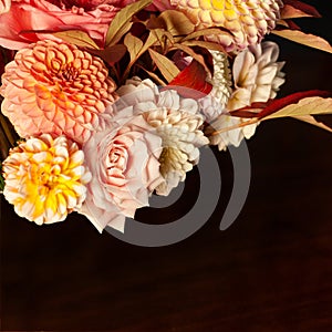 Floral composition of dahlia flowers, roses and autumn leaves.