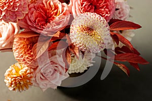 Floral composition of dahlia flowers, roses and autumn leaves.