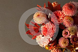 Floral composition of dahlia flowers, roses and autumn leaves.