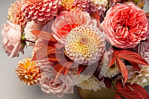 Floral composition of dahlia flowers, roses and autumn leaves.