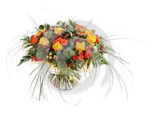 Floral composition of orange roses, hypericum and fern. Flower arrangement in a transparent glass vase. Isolated on white.