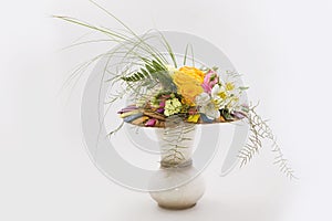 Floral composition of orange roses, hypericum and fern. Flower arrangement in a transparent glass vase. Isolated on white.