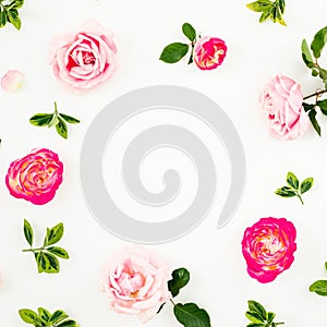 Floral composition of pastel pink roses flowers and green leaves on white background. Flat lay, top view. Spring time frame backgr