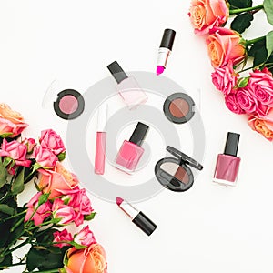 Floral composition with roses, buds, green leaves and feminine cosmetics on white background. Flat lay, top view. Spring backgroun