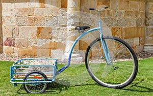Floral decoration for celebrating an outdoor party with a bicycle, vintage blue tricycle in the garden.