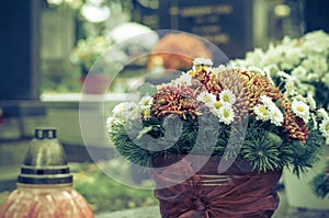 Floral decoration on grave during All Saints Day in the cemetery