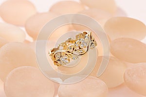 Floral design gold ring with diamonds on pink background