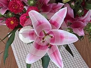 Floral display including Flashpoint pink and white Oriental Trumpet Lily closeup