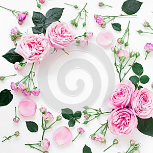 Floral frame composition with roses flowers, leaves and buds on white background. Flat lay, top view. Frame background