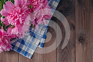 Floral frame with pink peonies on wooden background