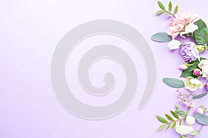 Floral frame with pink roses, white flowers, branches, leaves and petals on purple background. Flat lay, top view