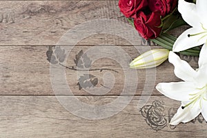 Floral frame with stunning white lilies and red roses on wooden background. Copy space. Wedding, gift card, valentine's day