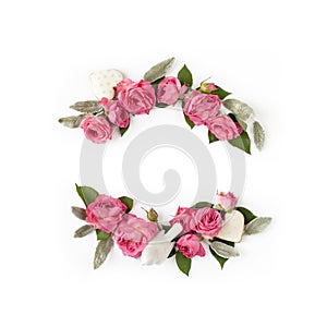 Floral frame wreath of rose flower buds, leaves and romantic decorations on white background mockup. Flat lay, top view
