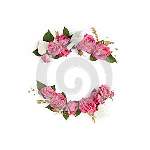 Floral frame wreath of rose flower buds, leaves and romantic decorations on white background mockup. Flat lay, top view