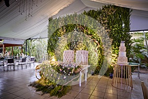 Floral green wall backstage main wedding table with cake photo