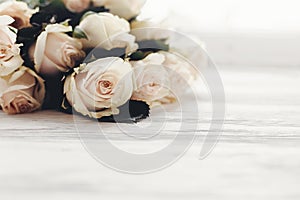 Floral greeting card mockup. White roses on wooden background, s