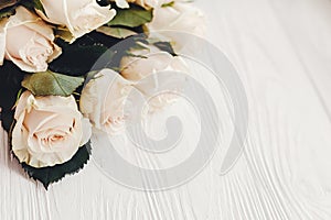 Floral greeting card mockup. White roses on wooden background, s