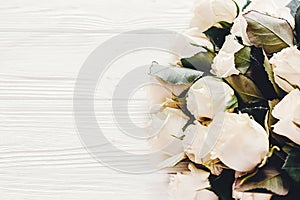 Floral greeting card mockup. White roses on wooden background, s