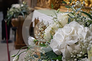 Floral ornamentation inside a worship space, church. Flower arrangements predominantly white and green