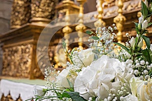 Floral ornamentation inside a worship space, church. Flower arrangements predominantly white and green