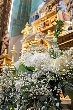 Floral ornamentation inside a worship space, church. Flower arrangements predominantly white and green