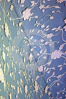 Floral ornaments on blue wall and ceiling of an old building interior