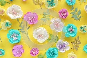 Floral pattern of colorful handmade flowers and paper leaves