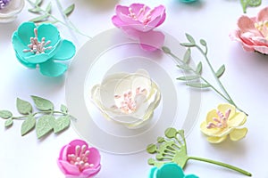 Floral pattern of colorful handmade flowers and paper leaves.