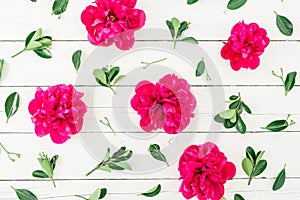 Floral pattern of peony and leaves on white wooden background. Flat lay, top view. Pattern made of flowers