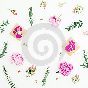 Floral round frame of pink peonies, roses, hypericum and eucalyptus branches and gifts on white background. Valentine day