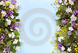 Floral summer background on a blue table with wildflowers and jasmine. View from above. Summer mood.