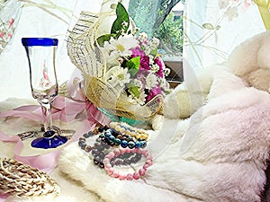 Florals and wine glass and stone jewelry on fur.