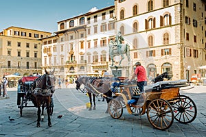 Florence, Italy - August 25, 2020: Horse-drawn carriages with drivers waiting for tourists in Piazza della Signoria