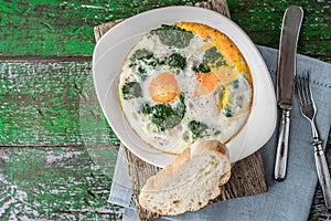 Florentine eggs with pureed spinach on the wooden table horizontal