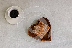 Florentines on a heart shaped wooden plate and cup of coffee