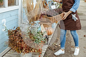 Floriculturist in an apron standing by a lodge