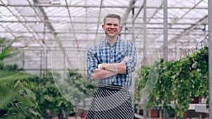 Florist with arms crossed in greenhouse