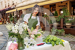 Florist Arranging Fresh Flowers at Outdoor Market. Florist at work. Workplace. Small business