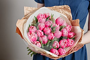 Florist girl with peony flowers or pink tulips Young woman flower bouquet for birthday mother's day.