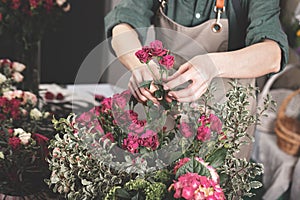 Florist make gift bouquets. Graceful female hands make a beautiful bouquet. Florist workplace. Small business concept