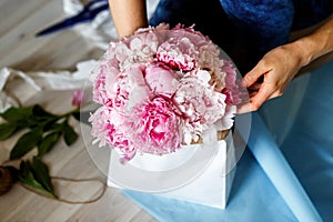 Florist making a bouguet of peonies