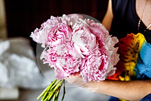 Florist making a bouguet of peonies