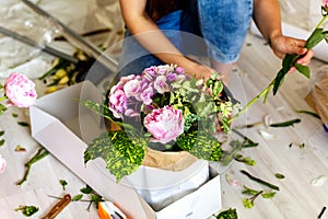 Florist making a bouguet of peonies