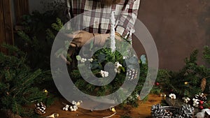 Florist making Christmas floral arrangement in flower shop studio.