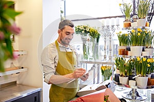 Florist man with clipboard at flower shop counter