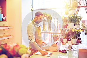 Florist man with clipboard at flower shop counter